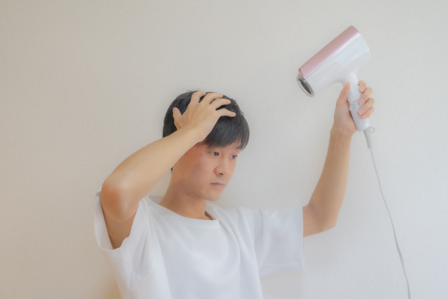 【中学生限定】雨の日の通学前に30秒!前髪キープできる簡単裏ワザ_男性がドライヤーで髪を乾かしている画像